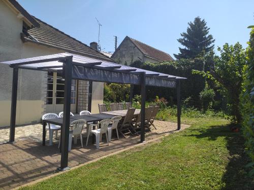 einen Tisch und Stühle unter einer Pergola im Hof in der Unterkunft La Tribu de Beauval 6ch grand terrain et parking privé in Saint-Aignan