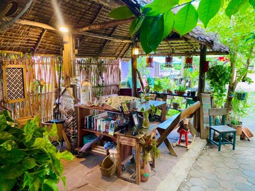 een buitenruimte met een tafel en een boekenplank bij Thai Guesthouse in Kanchanaburi