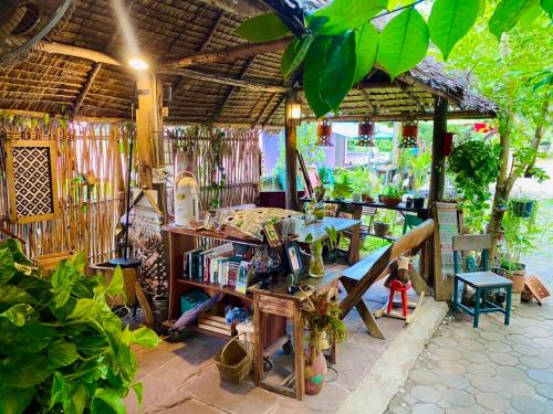 an outdoor area with a table and a book shelf at Thai Guesthouse in Kanchanaburi