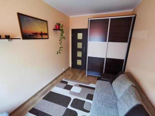 een woonkamer met een schuifdeur en een tapijt bij Apartament Witosa in Giżycko