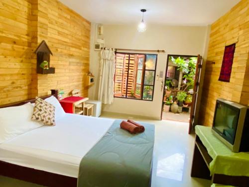 um quarto com uma cama grande e uma televisão em Thai Guesthouse em Kanchanaburi