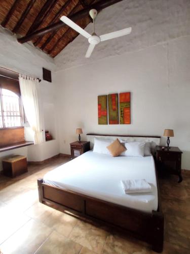 a bedroom with a large bed with a ceiling fan at Giron Chill Out Hotel Boutique in Girón