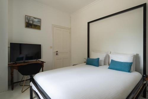 a bedroom with a bed and a desk and a television at Les Horizons - SPA-JACUZZI - MASSAGE- SAUNA - 4 SAISONS - Piscine chauffée Toute l'année - 800m centre ville Nyons in Nyons