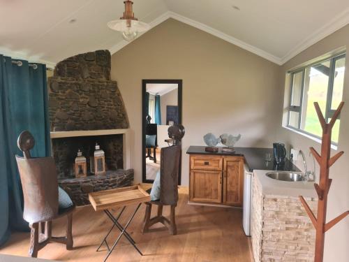 a living room with a fireplace and a sink at Wetlands Game Lodge in Wakkerstroom