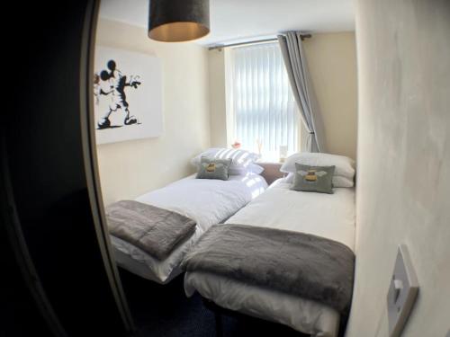 une chambre avec deux lits et un miroir dans l'établissement Winter Gardens North Pier 2 Bed, à Blackpool