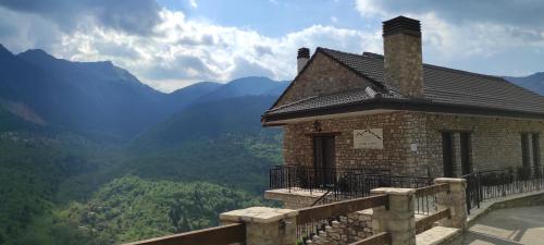 a building on a balcony with mountains in the background at Δωμάτια με θέα in Méga Khoríon