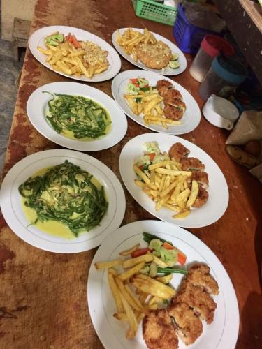 a table with plates of food and french fries at Wahyu Homestay 1 in Nusa Lembongan