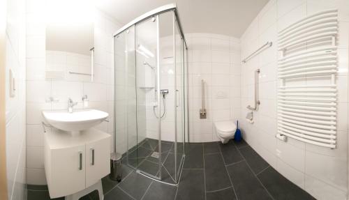 a white bathroom with a sink and a shower at Alpbachstrasse 4, Meiringen in Meiringen