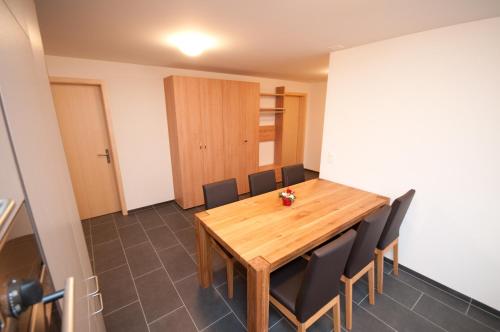 a dining room with a wooden table and black chairs at Alpbachstrasse 4, Meiringen in Meiringen