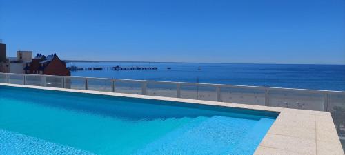 uma piscina com o oceano ao fundo em mstudio I Monoambiente VIRA em Puerto Madryn