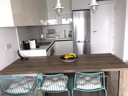 a kitchen with a table with a bowl of bananas on it at Blue Escape (Beach Seafront) in Larnaka