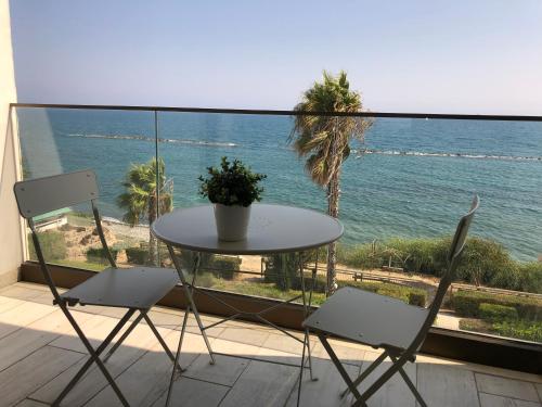 a table and chairs on a balcony with a view of the ocean at Blue Escape (Beach Seafront) in Larnaka
