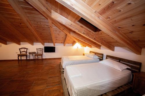 two beds in a room with wooden ceilings at Berati Castle Hotel in Berat