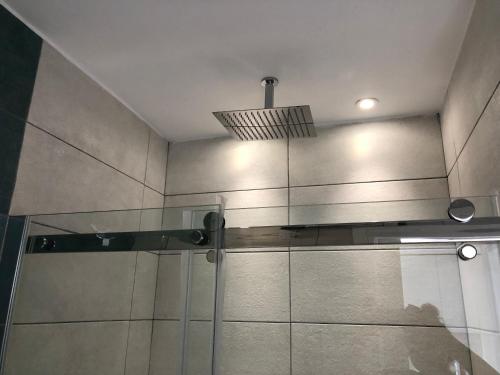 a shower with a glass door and a ceiling at Blue Escape (Beach Seafront) in Larnaka