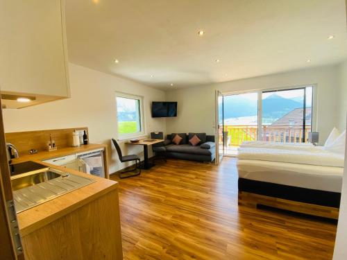 a room with a bed and a kitchen and a couch at Ferienappartements Familie Jakob in St. Wolfgang