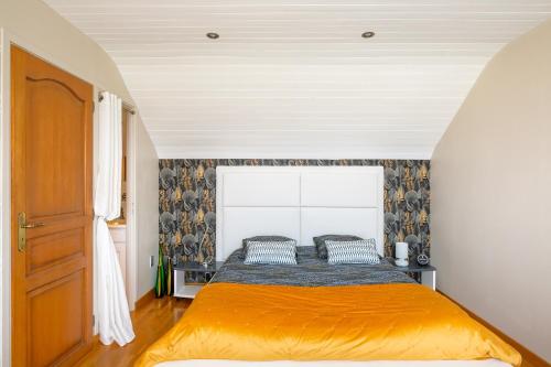 1 dormitorio con 1 cama con colcha de color naranja en Le Phare de Trézien, en Plouarzel