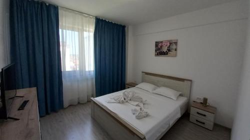 una camera da letto con un letto con tende blu e una finestra di Apartament Matei a Tulcea