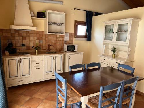 a kitchen with a wooden table and blue chairs at Residence Ulivi in Cavaion Veronese
