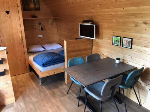 een kamer met een bed en een tafel en stoelen bij Tiny House de Wood Lodge in Ootmarsum