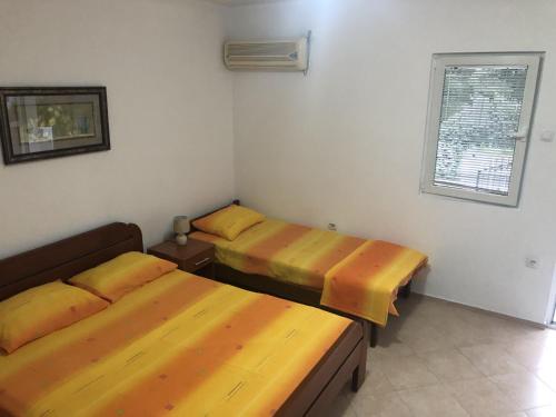 a room with two beds and a window at Apartmani Sunce in Bar
