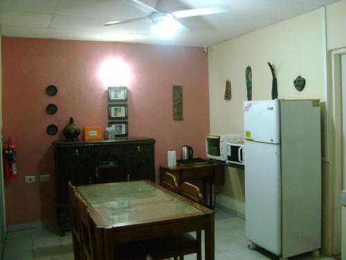 a kitchen with a table and a white refrigerator at Hospedaje El Paye in Corrientes
