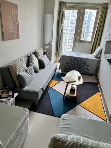 a living room with a couch and a rug at Beautiful 1bed condo Nr Airport, MOA, Makati, Bay in Manila