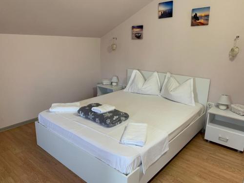 Una cama blanca con una bolsa encima. en R i A N A 2, en Eforie Sud