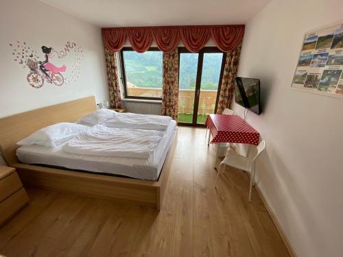 a bedroom with a bed and a window and a table at Laimerhof in Rifiano