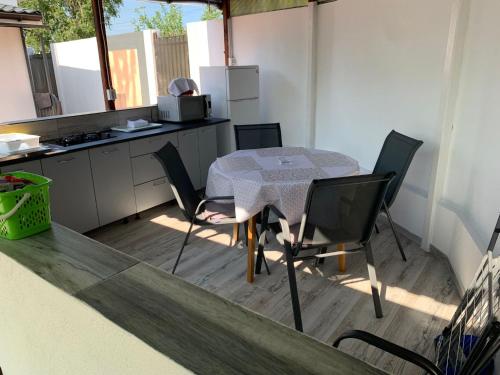 Una cocina con una mesa y sillas en una cocina. en R i A N A 2, en Eforie Sud