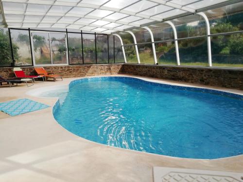 - une grande piscine dans un bâtiment doté de fenêtres dans l'établissement maison piscine privée proche de Rodez, à Cassagnes-Bégonhès