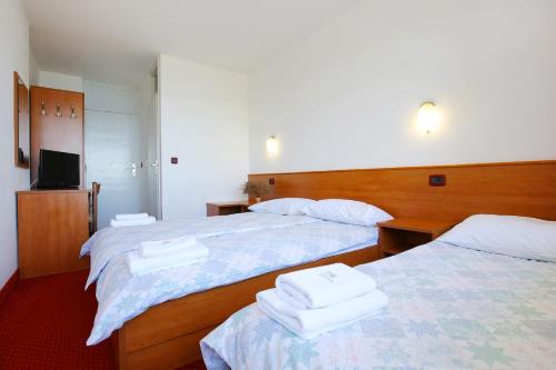 ein Hotelzimmer mit 2 Betten und Handtüchern darauf in der Unterkunft Hotel Luka in Luka