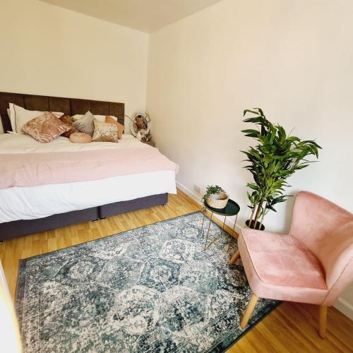a bedroom with a bed and a chair and a rug at Hale Lodge in London