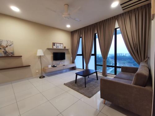 a living room with a couch and a tv at Mid Valley Southkey Mosaic Cozy Suite at Johor Bahru in Johor Bahru