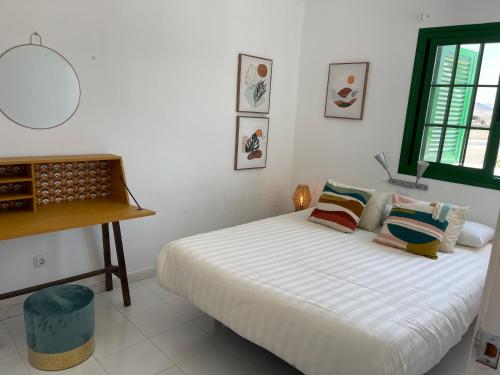 
a bedroom with a white bed and white walls at Cotillo Lagoons Apartment in El Cotillo

