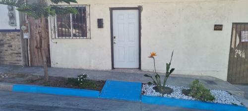 a house with a door and a flower in front of it at Departamento Ruze Rosarito Privado-Tranquilo in Plan Libertador