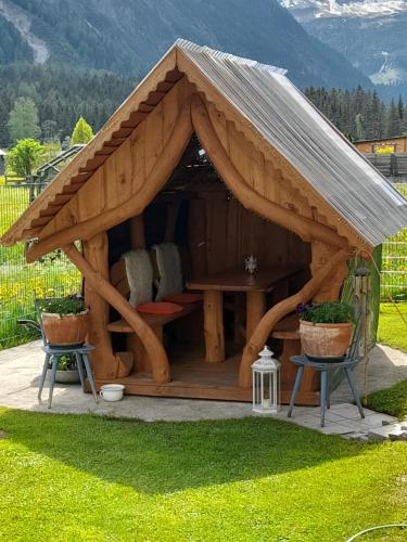 einen Pavillon mit einem Tisch und Stühlen im Hof in der Unterkunft Haus Sonnenschein in Holzgau