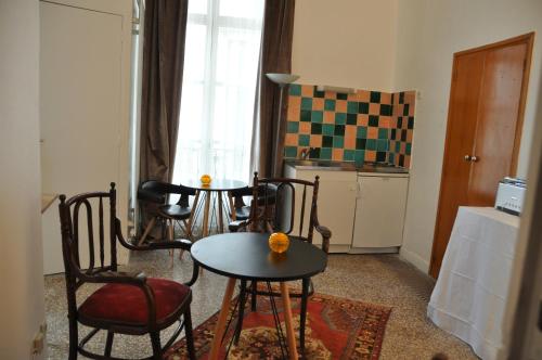 Una sala de estar con mesa y sillas y una cocina. en Ida Chambres d'hôtes B&B, en Montpellier
