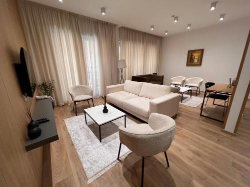 a living room with a white couch and chairs at Habitat Hotel Tirana in Tirana