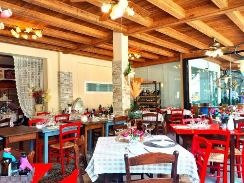 a dining room with tables and red chairs at Hotel Danubio in Lido di Jesolo