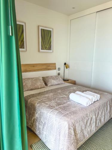 a bedroom with a bed with two towels on it at IntempoCarrera - Apartment at Intempo Building in Benidorm