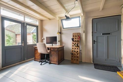 a home office with a desk and a door at Private Characteristic farmhouse near the lake in Andijk
