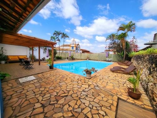 a backyard with a swimming pool and a house at Pousada Toro Real in Tiradentes