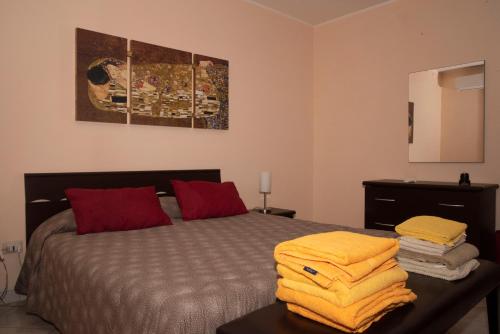 a bedroom with a bed with yellow towels on a table at Casa Rosanna in Giardini Naxos
