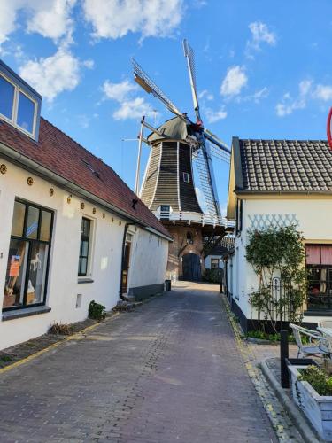 eine Windmühle in der Mitte einer Straße mit Gebäuden in der Unterkunft Hausboot Lucky in Hattem