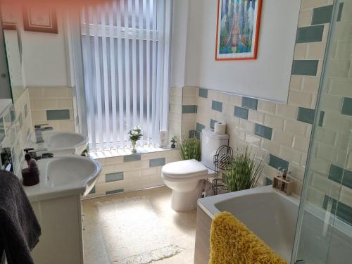 a bathroom with a toilet, sink and tub at BELLEVA Adults Only in Blackpool