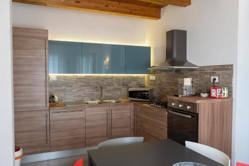 a kitchen with wooden cabinets and a sink and a stove at IL Sogno in Montesano sulla Marcellana