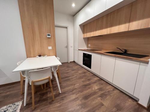 a kitchen with a white table and white cabinets at Habitat Hotel Tirana in Tirana