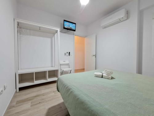 a white bedroom with a bed and a window at Puerto benidorm center in Benidorm
