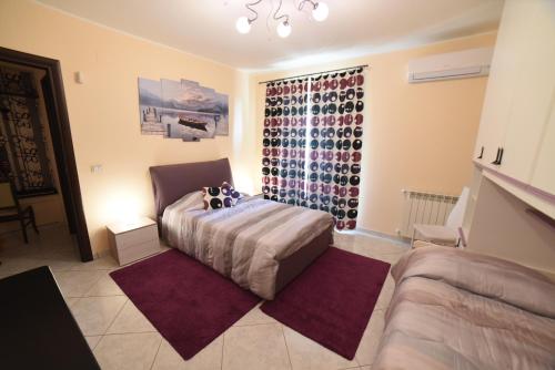 a bedroom with a bed and a window with wine bottles at Casa Rosanna in Giardini Naxos