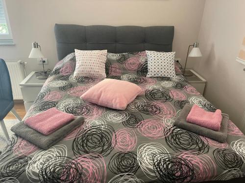 a bedroom with a bed with pink pillows at Apartman Spa Bačka in Bačka Palanka